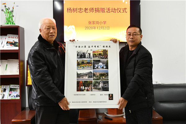 杨树忠(左一)向张家岗小学捐赠摄影图片.jpg